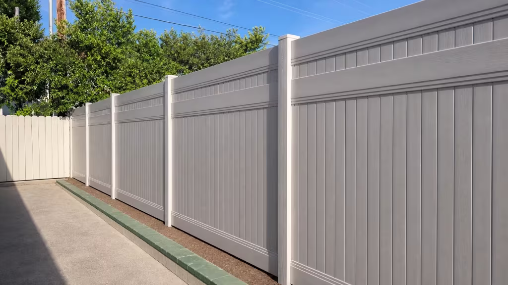 Tan vinyl privacy fence with a lattice top running past an old pale fence section in Glendale