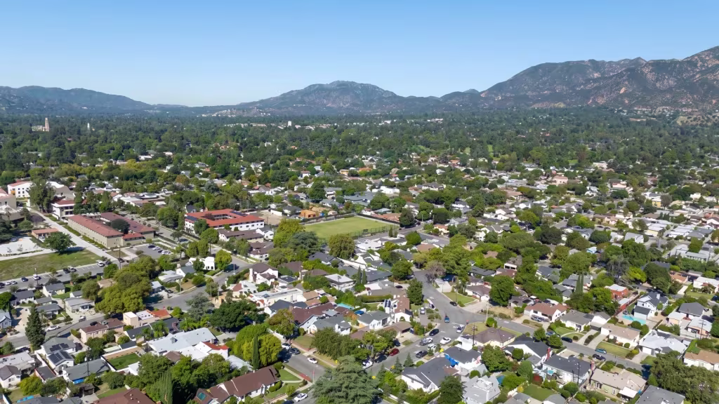 Altadena's suburban grid unfolds at the foothills in this high aerial oblique panoramic view