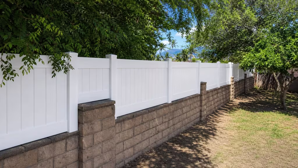 Taller masonry piers and dark capstones flank this White vinyl privacy wall topper in Azusa