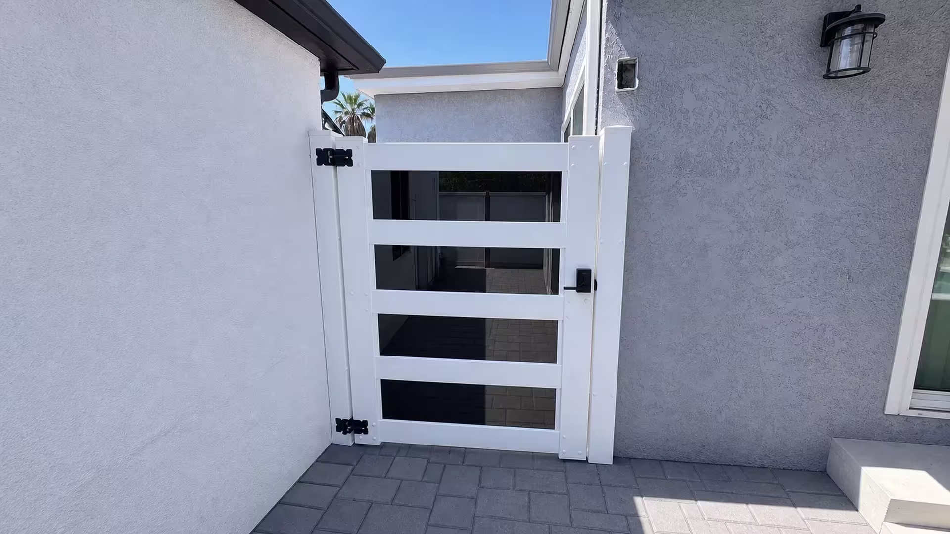 This Arleta side yard now has a White vinyl privacy gate, its acrylic accent openings set beside a sliding glass door