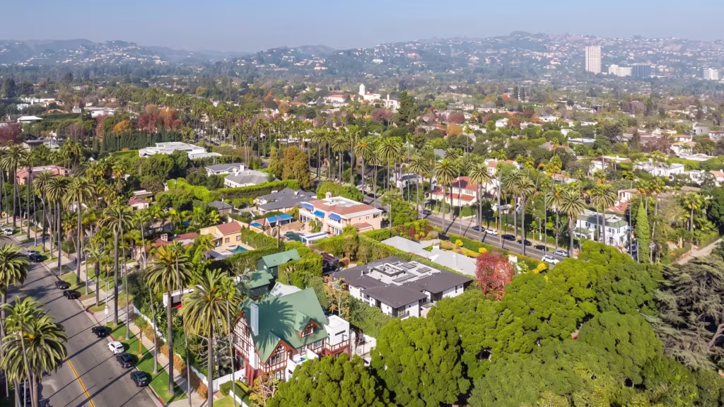 Palms and civic lawns frame a landscaped residential district with the city beyond in Beverly Hills