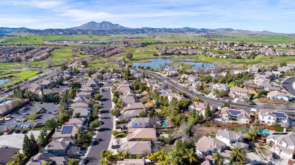 Suburban neighborhoods spread across Brentwood alongside green open land, waterways, and distant hills