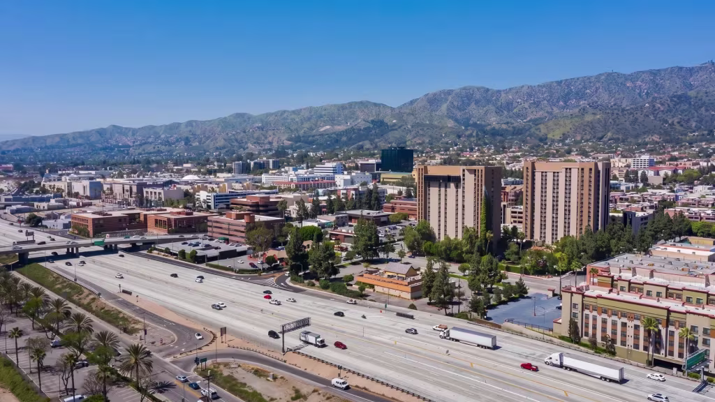 A freeway curves through Burbank's urban district, set against the mountains in this aerial view