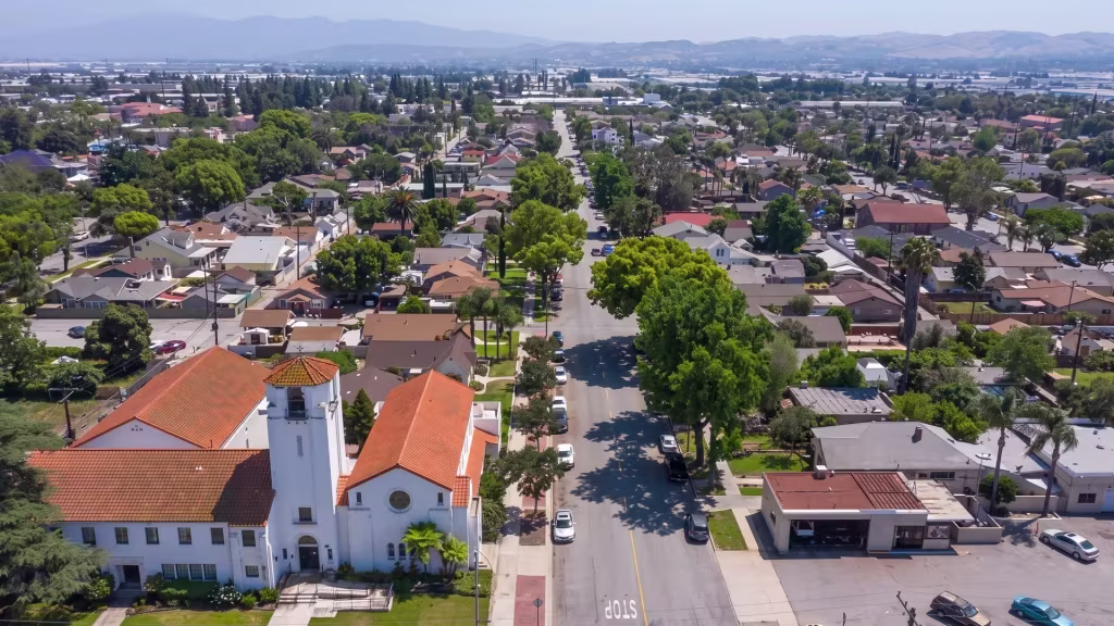 Chino's residential and civic district spreads beneath a mountain backdrop in this high aerial frame