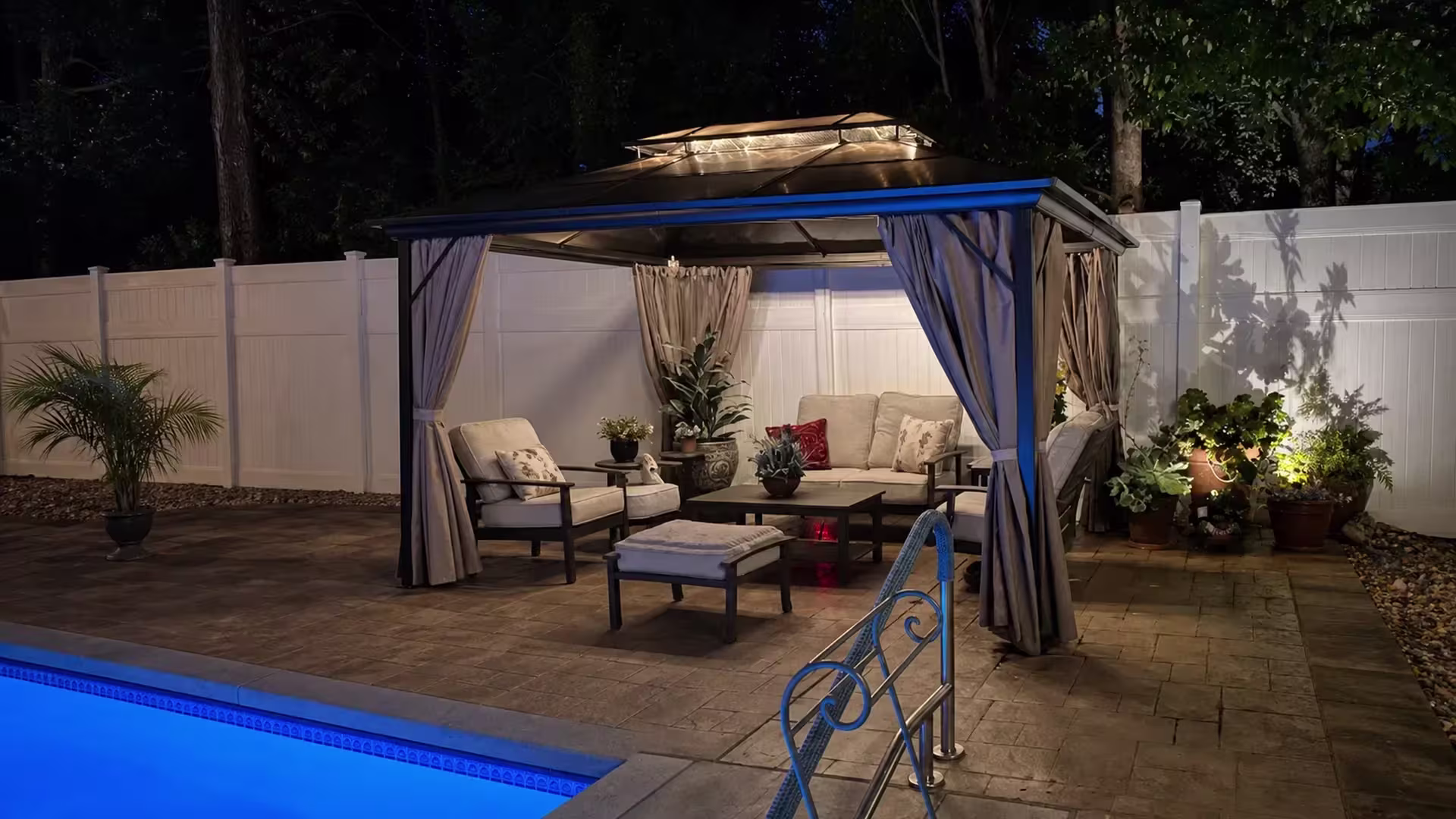 White vinyl privacy fence traces the edge of a poolside patio in Studio City