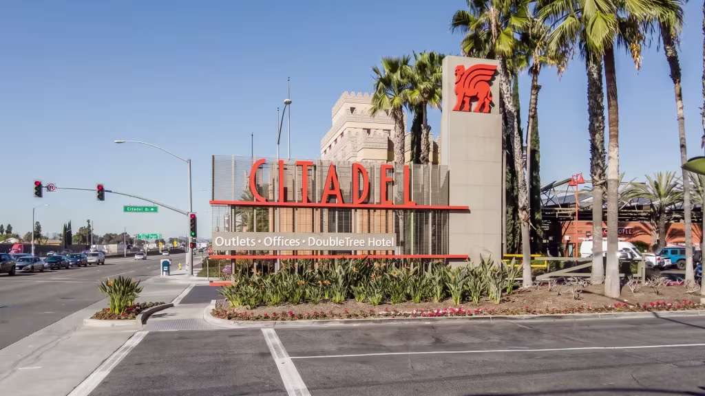 A commercial landmark stands along a palm-lined street at ground level here in Commerce