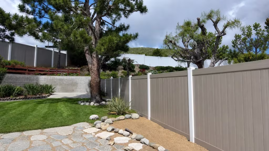 In this Sylmar yard, a mature pine and a distant ridge overlook the Weathered Blend vinyl privacy fence line
