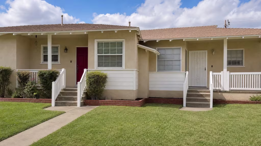 Dark red six-panel doorway framing sits above a White vertical vinyl picket fence spanning this Burbank porch