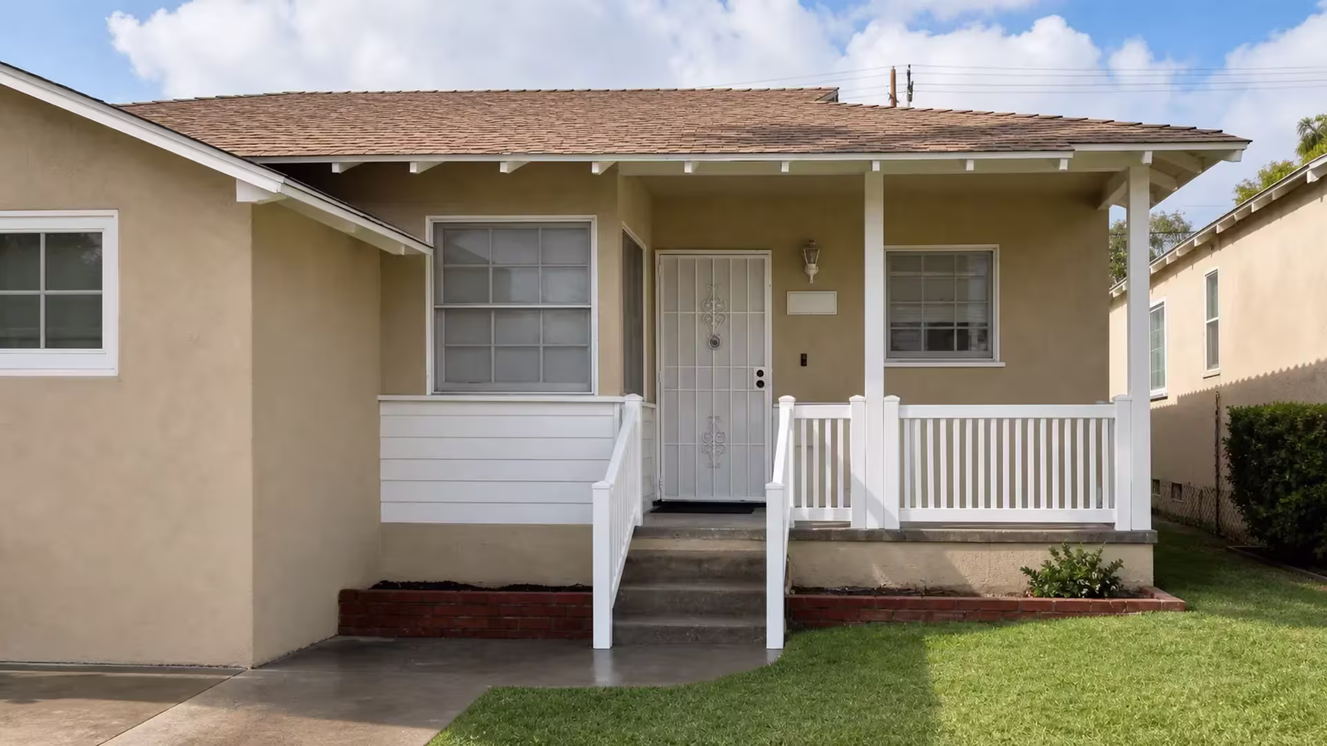 Concrete steps rise beneath a White vertical vinyl fence railing at this Burbank porch