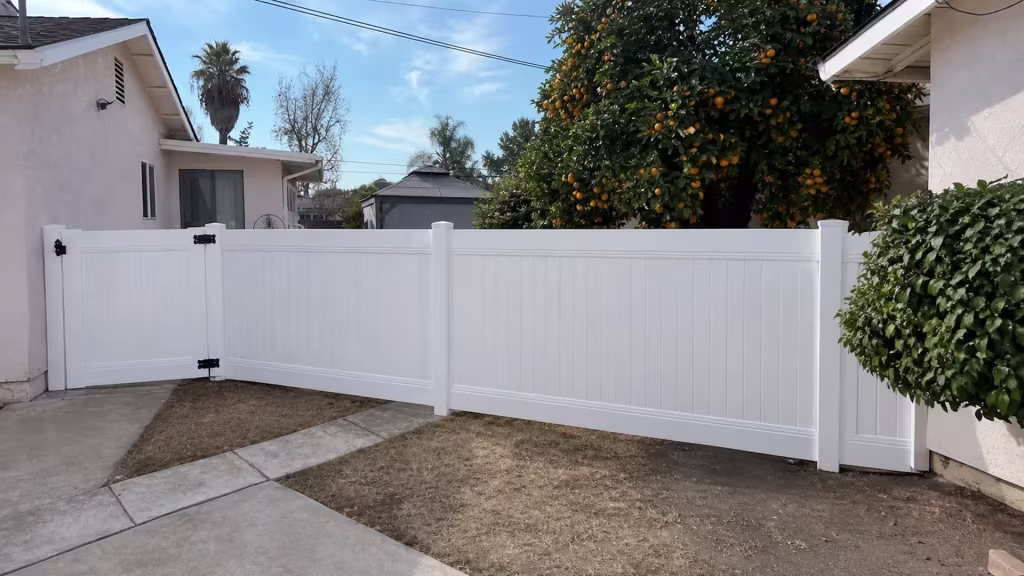 Overhead utility lines and a distant palm rise above this White vinyl fence and gate in Arcadia
