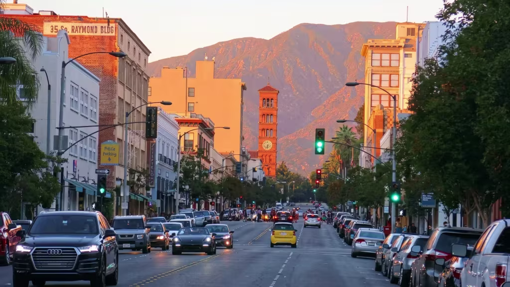 A busy downtown avenue runs through El Monte, with mountains rising behind it at ground level