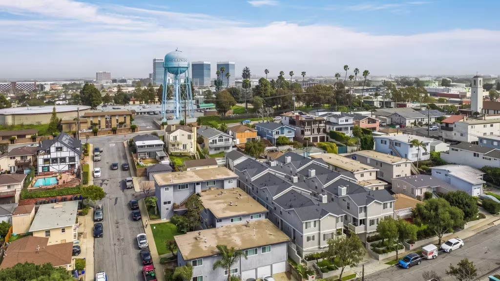 A water tower marks El Segundo's coastal low-rise neighborhood, with a distant skyline behind it