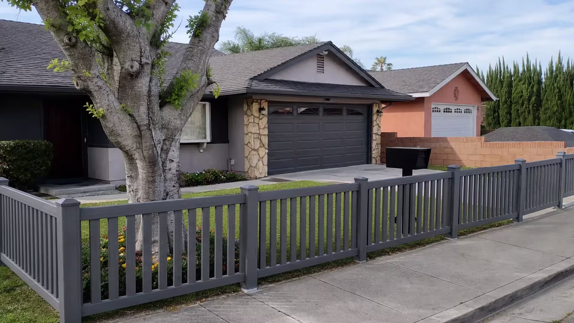 Arctic Blend vinyl picket fence tracing a Whittier yard past a mature tree and flower bed