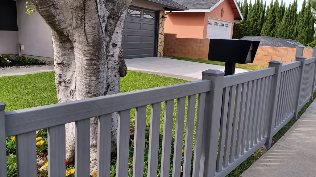 A subtle woodgrain finish carries this Arctic Blend vinyl picket fence diagonally toward a Whittier sidewalk