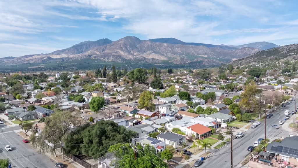Small-town neighborhoods spread beneath tall mountains in this elevated view over Fillmore