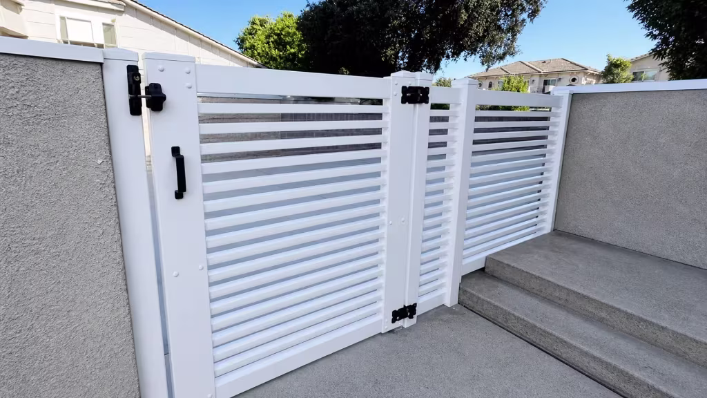 Descending concrete steps lead past this White vinyl horizontal picket fence between gray stucco walls in Arcadia