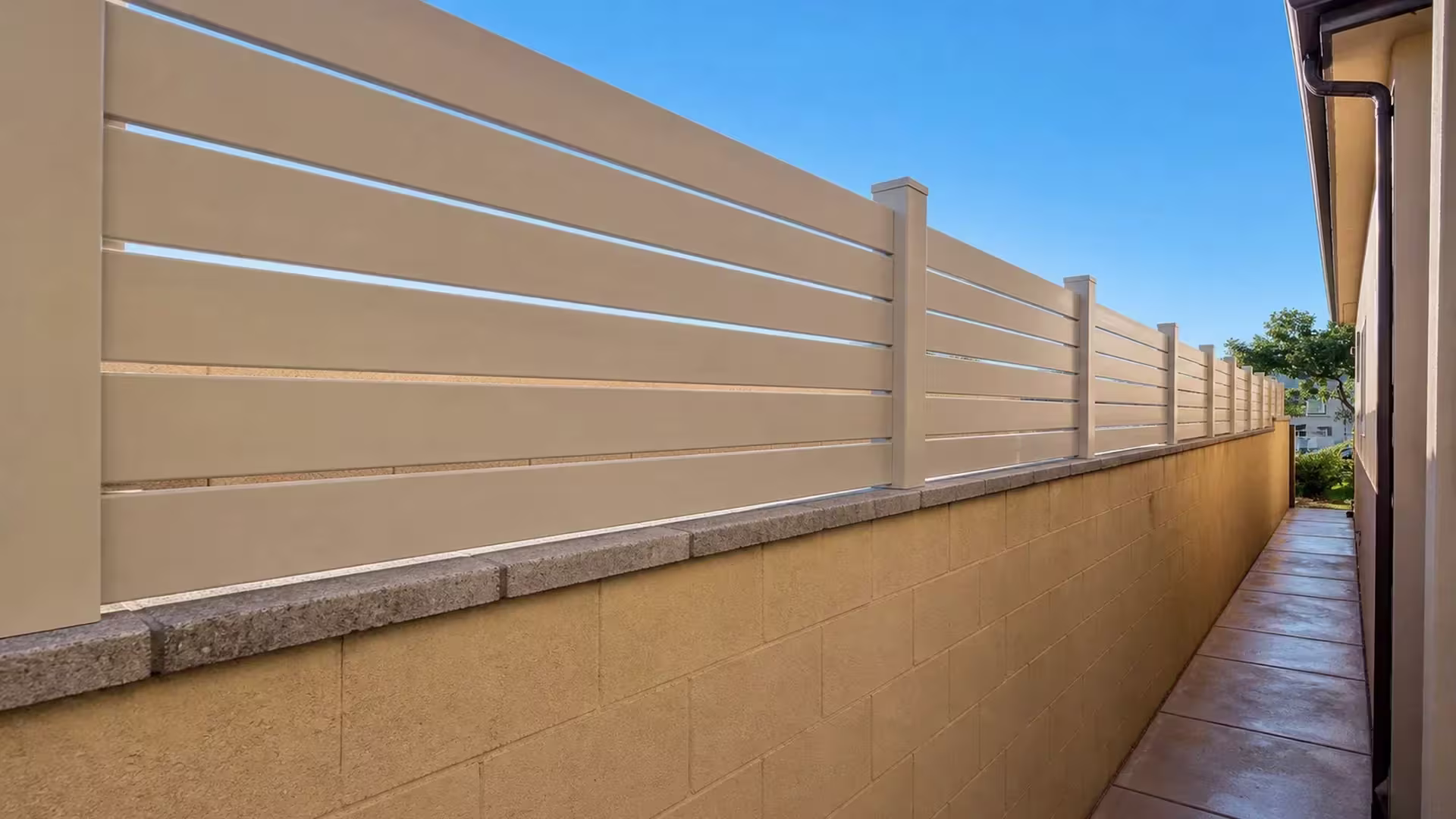 A long block wall with gray coping carries this Burbank passage's Tan vinyl topper, added for privacy