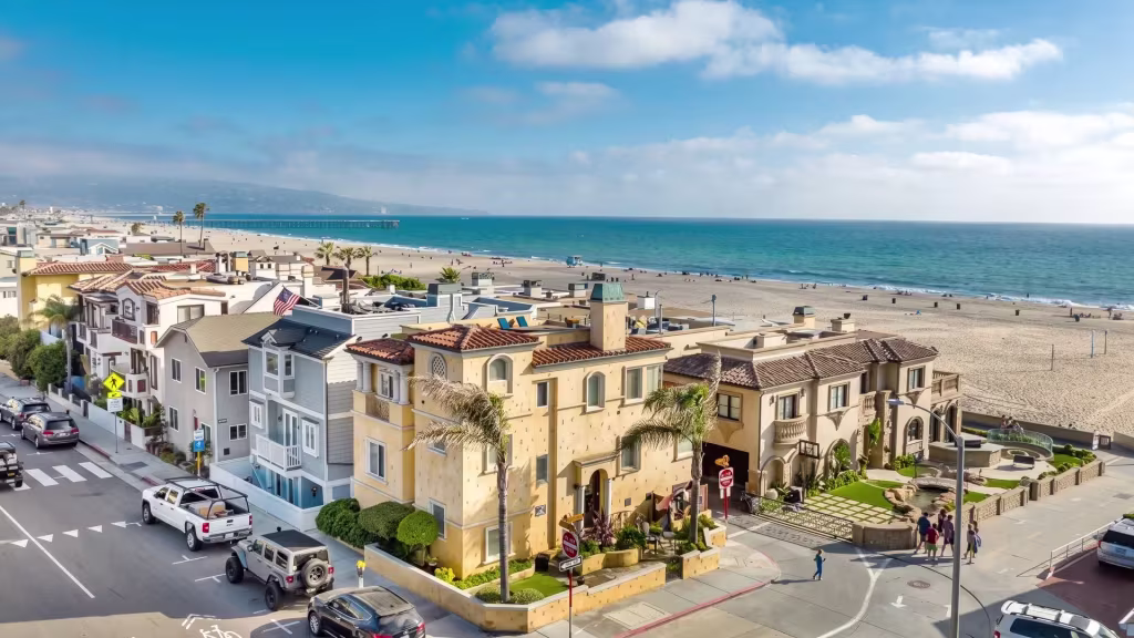 Beachfront homes in Hermosa Beach line a wide sandy shoreline facing the open ocean beyond