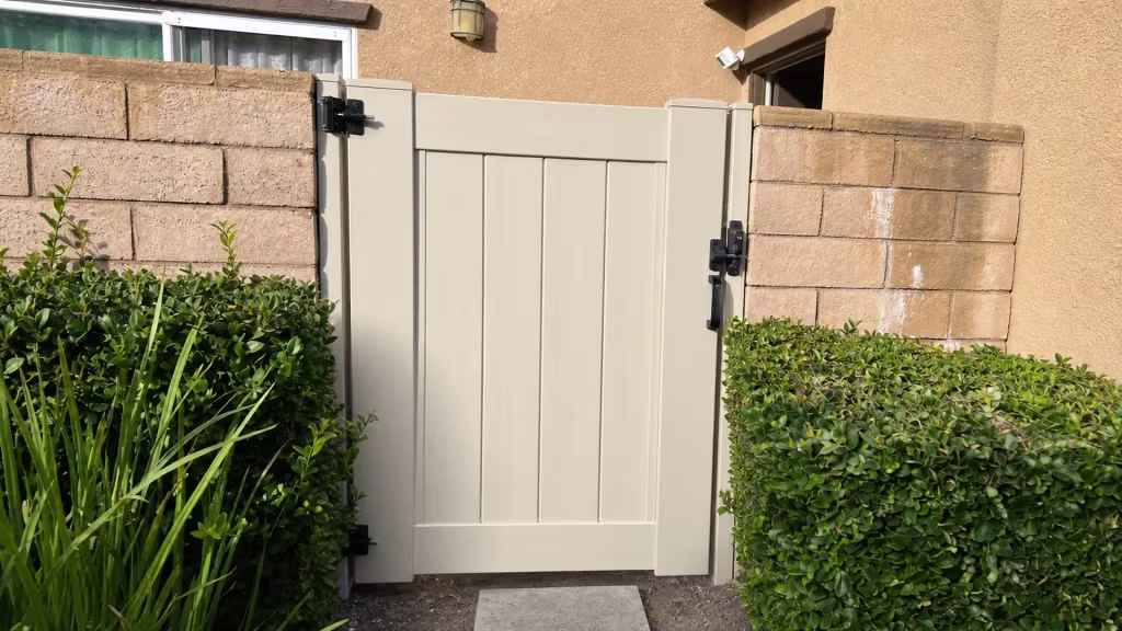 Black hinges on the left and a latch on the right secure this White vinyl gate leaf in Ontario