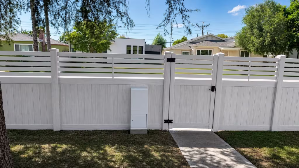 Open horizontal picket slats top a solid Aspen vinyl privacy fence run along a North Hollywood sidewalk