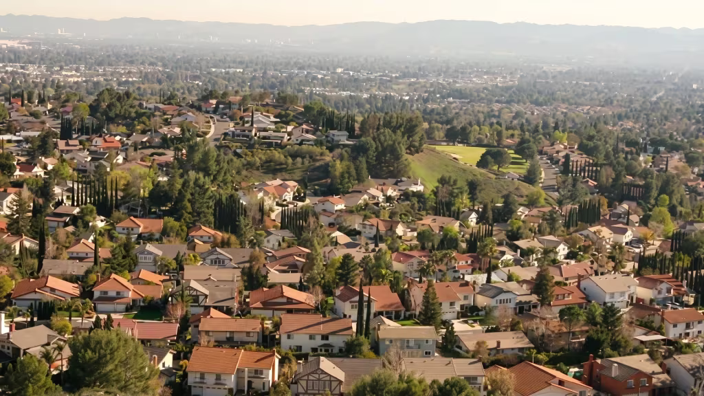 Tree-covered hillside neighborhoods in La Canada Flintridge open onto a wide valley in this elevated view