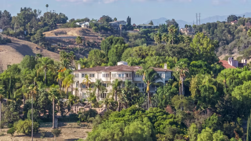 A large hillside estate sits amid dense greenery in La Habra Heights in this elevated oblique view
