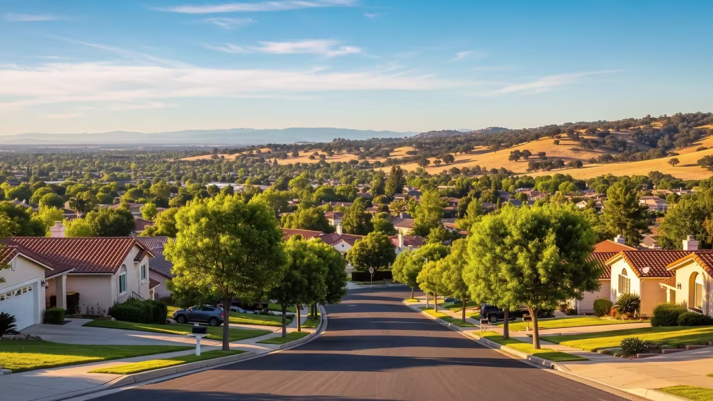 A quiet suburban street in La Puente runs toward golden hills sitting on the horizon