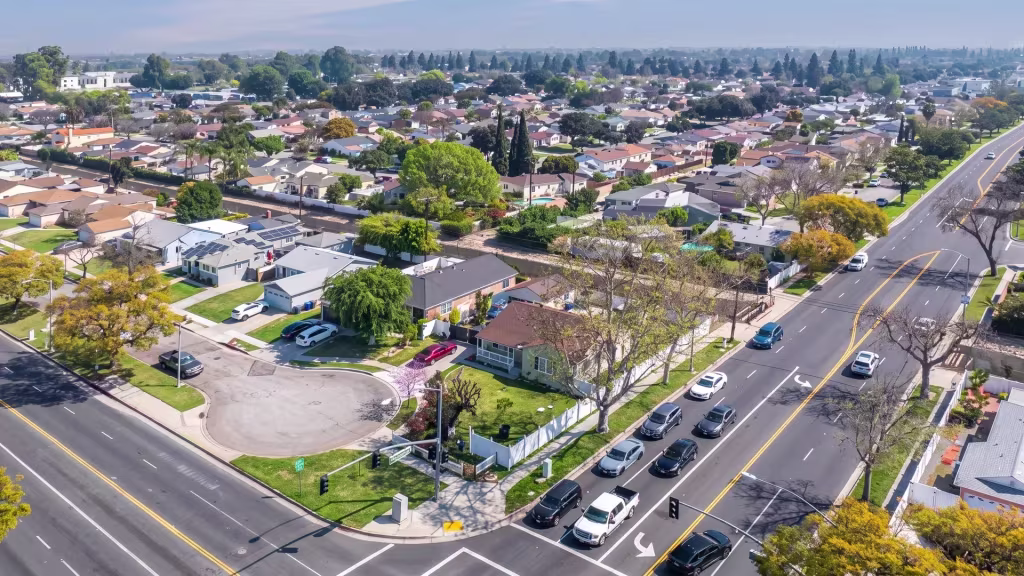 Suburban homes in Lakewood line a broad arterial road, captured from high aerial oblique overhead