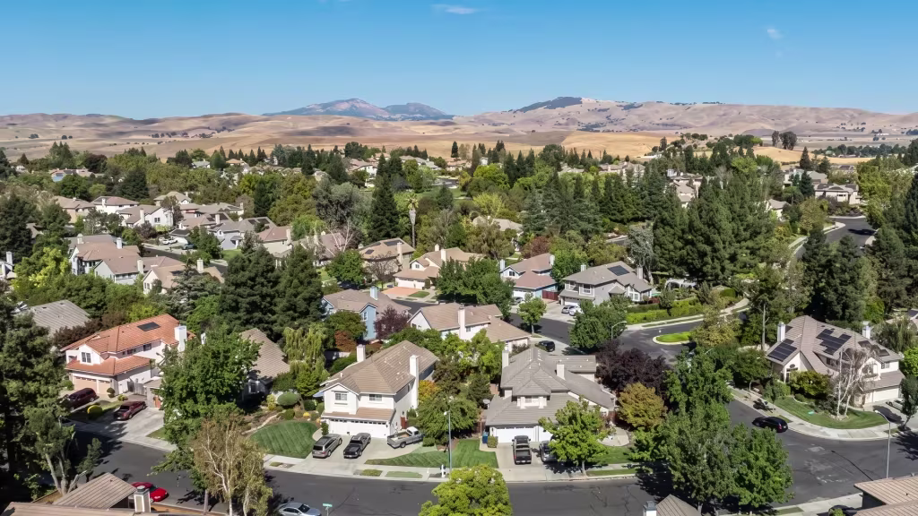 Open hills rise behind a leafy residential neighborhood on the edge of Livermore