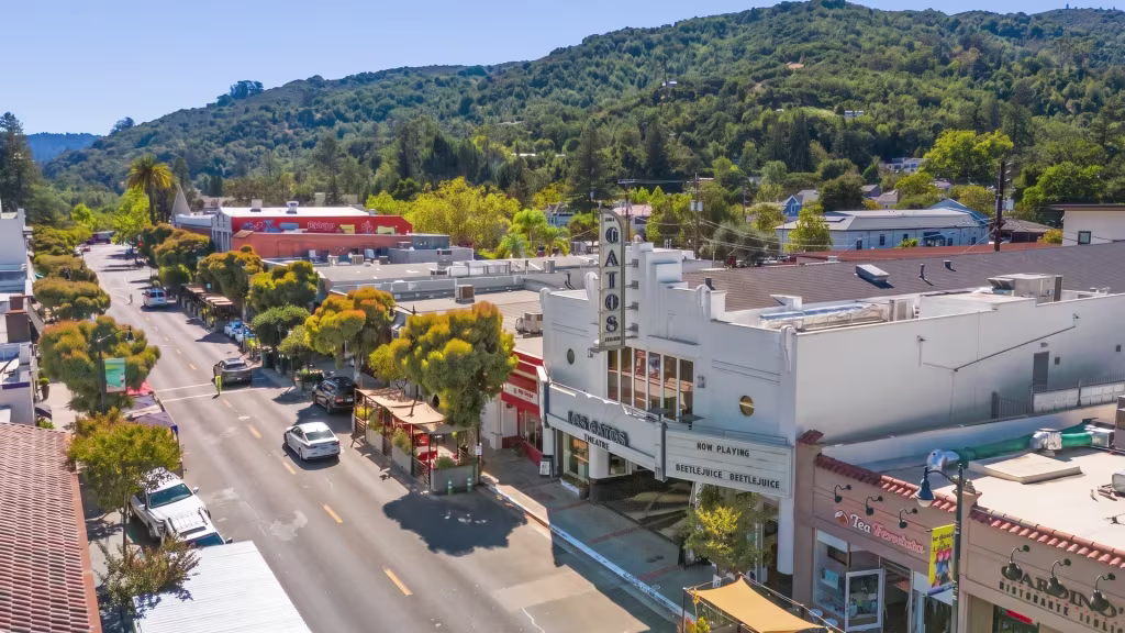 A historic theater anchors Los Gatos' tree-lined main street, with hills rising behind