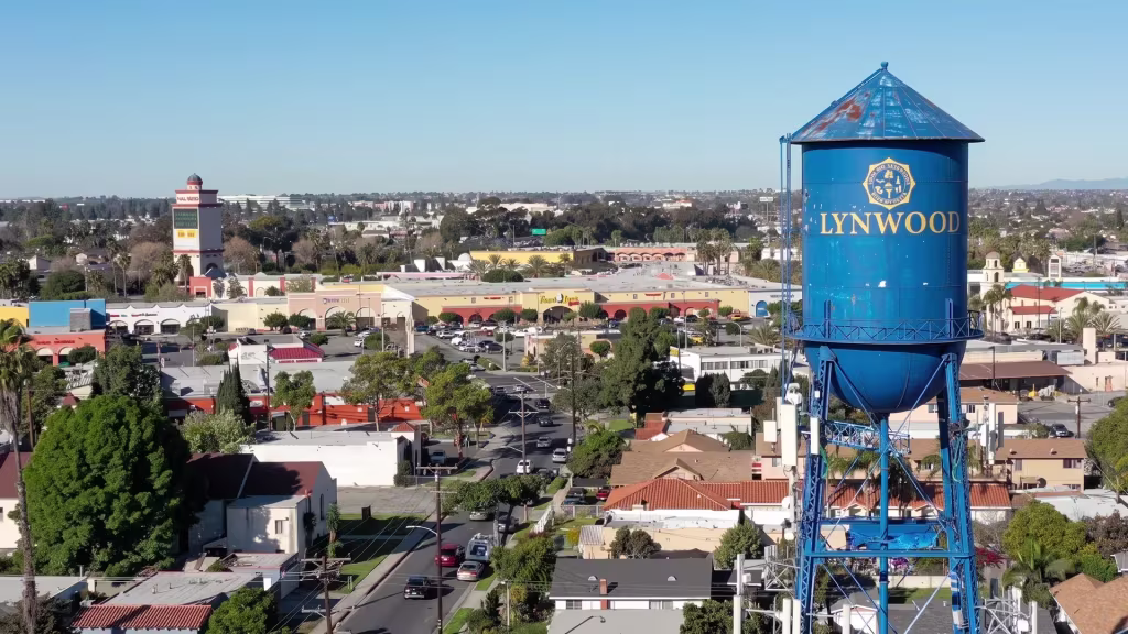 A water-tower landmark stands above Lynwood's low-rise neighborhood, seen from a high aerial vantage point