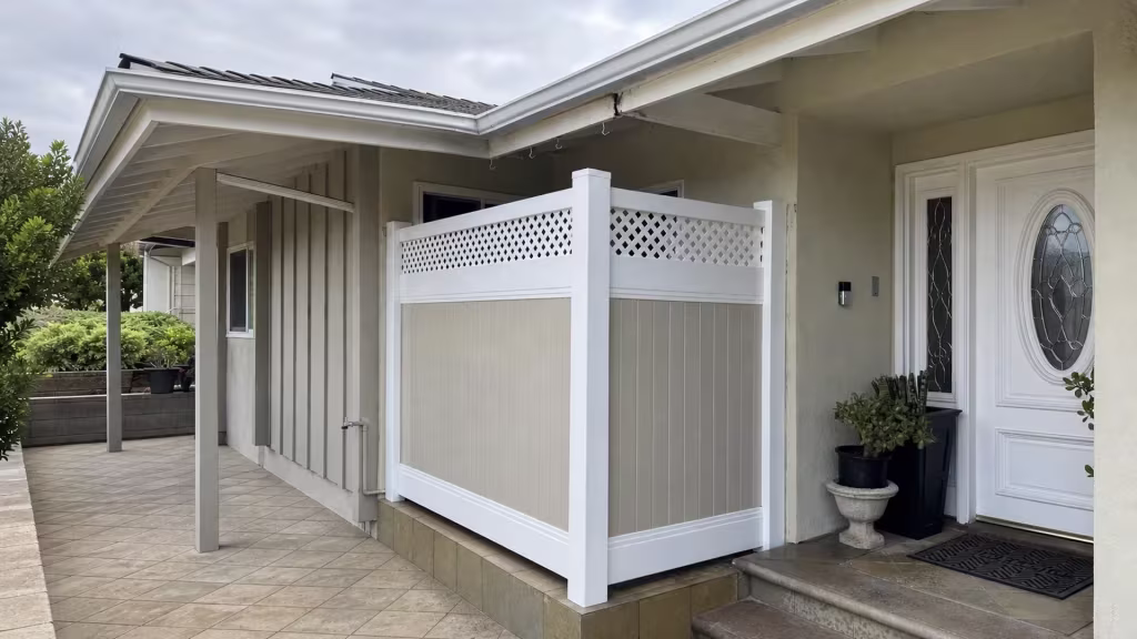 A black planter and a stone pedestal planter with succulents sit beside this Tan and White vinyl fence in Glendale