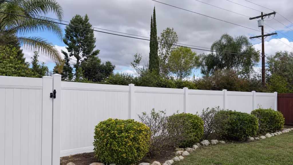 A gate return panel joins this White vinyl privacy fence through soil planting beds in West Hills