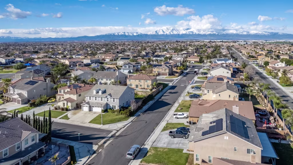 A residential neighborhood in Mira Loma sits beneath mountains rising behind it in this aerial frame