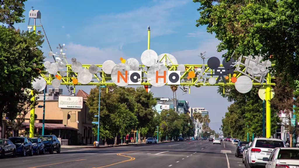 Street level in North Hollywood frames a neighborhood gateway along a commercial boulevard