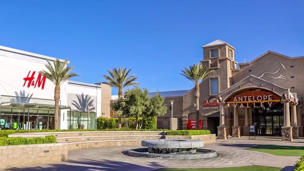 A retail landmark stands at street level in Palmdale, with mountains rising in the distance