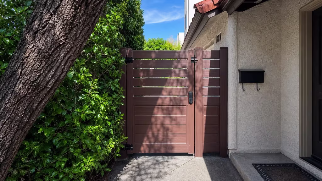 Dark Walnut vinyl gate with a picket top closing a side passage beside a stucco house wall