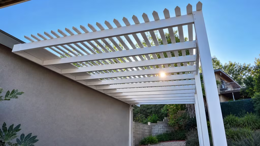 White vinyl pergola cover viewed from below, its square front post topped with a pointed pyramid cap