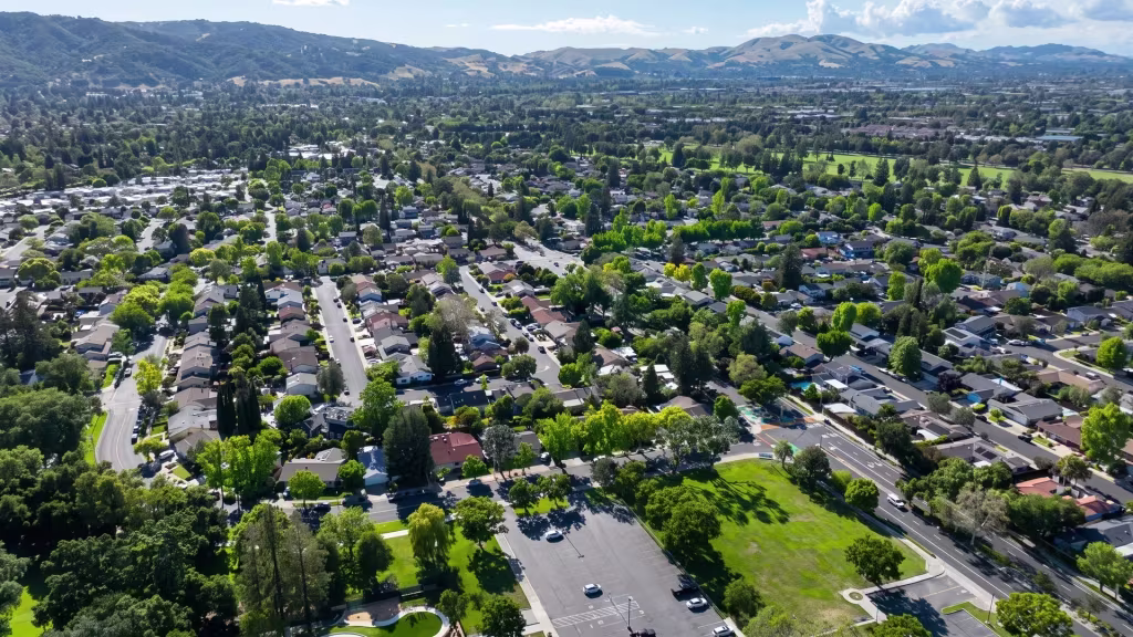 Leafy suburban neighborhoods and open parkland spread across Pleasanton, with hills closing the horizon
