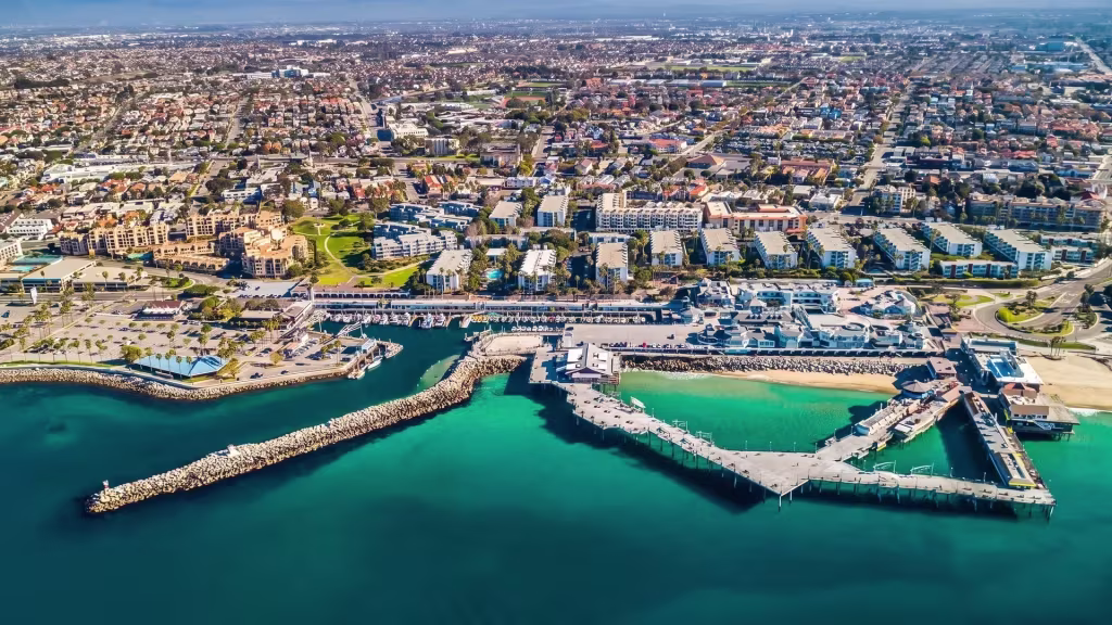Aerial view over Redondo Beach, where a harbor and marina sit beside the dense coastal city