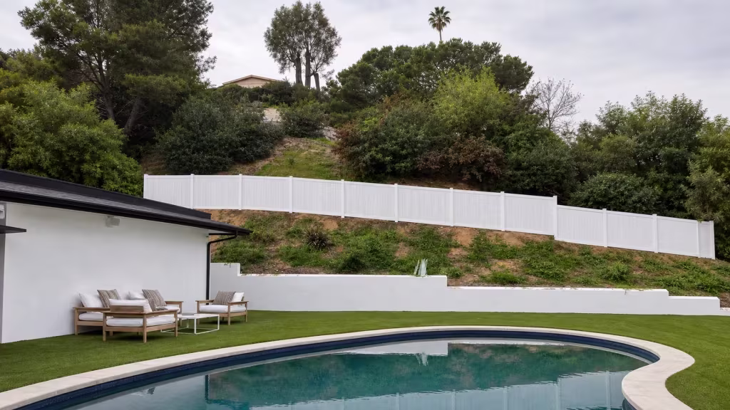 Aspen vinyl privacy fence framing a swimming pool with patio furniture on the Sherman Oaks hillside