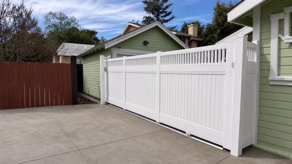 White vinyl fence lined with pickets runs past the garage and neighboring rooflines on this Pasadena property