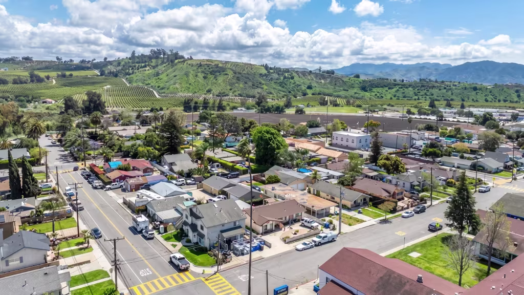 Aerial panorama over Somis, a rural town center surrounded by green fields and low hills