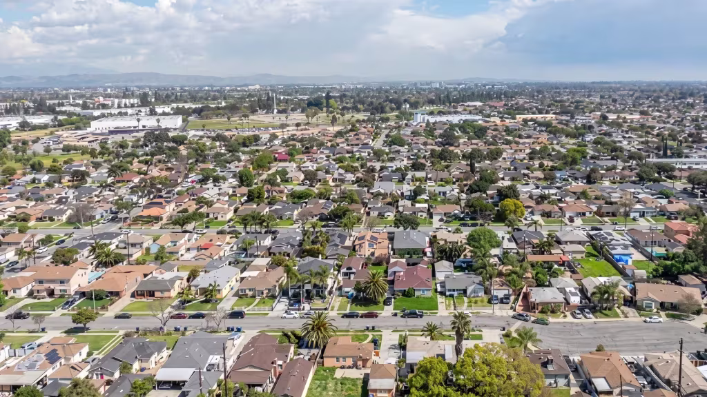 Aerial panorama over South Gate, a dense suburban expanse stretching toward a mountain horizon