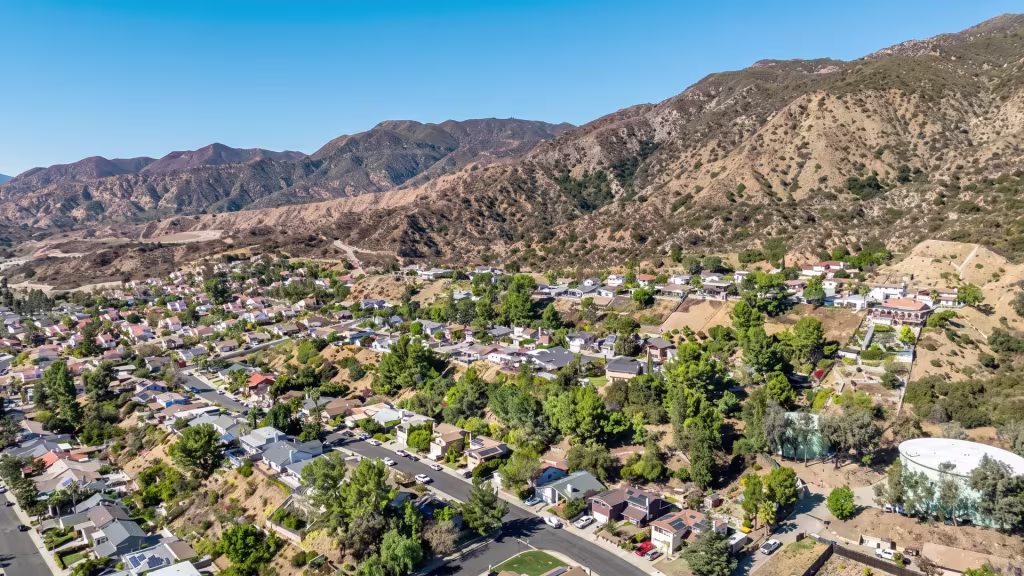 Elevated panorama over Sylmar, suburban neighborhoods spread beneath a line of rugged mountains