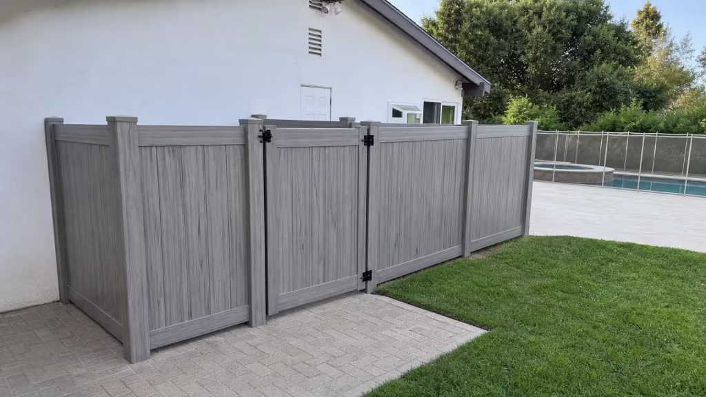 Coastal Cedar vinyl fence encloses Encino mechanical equipment with a raised pool and metal railing visible beyond