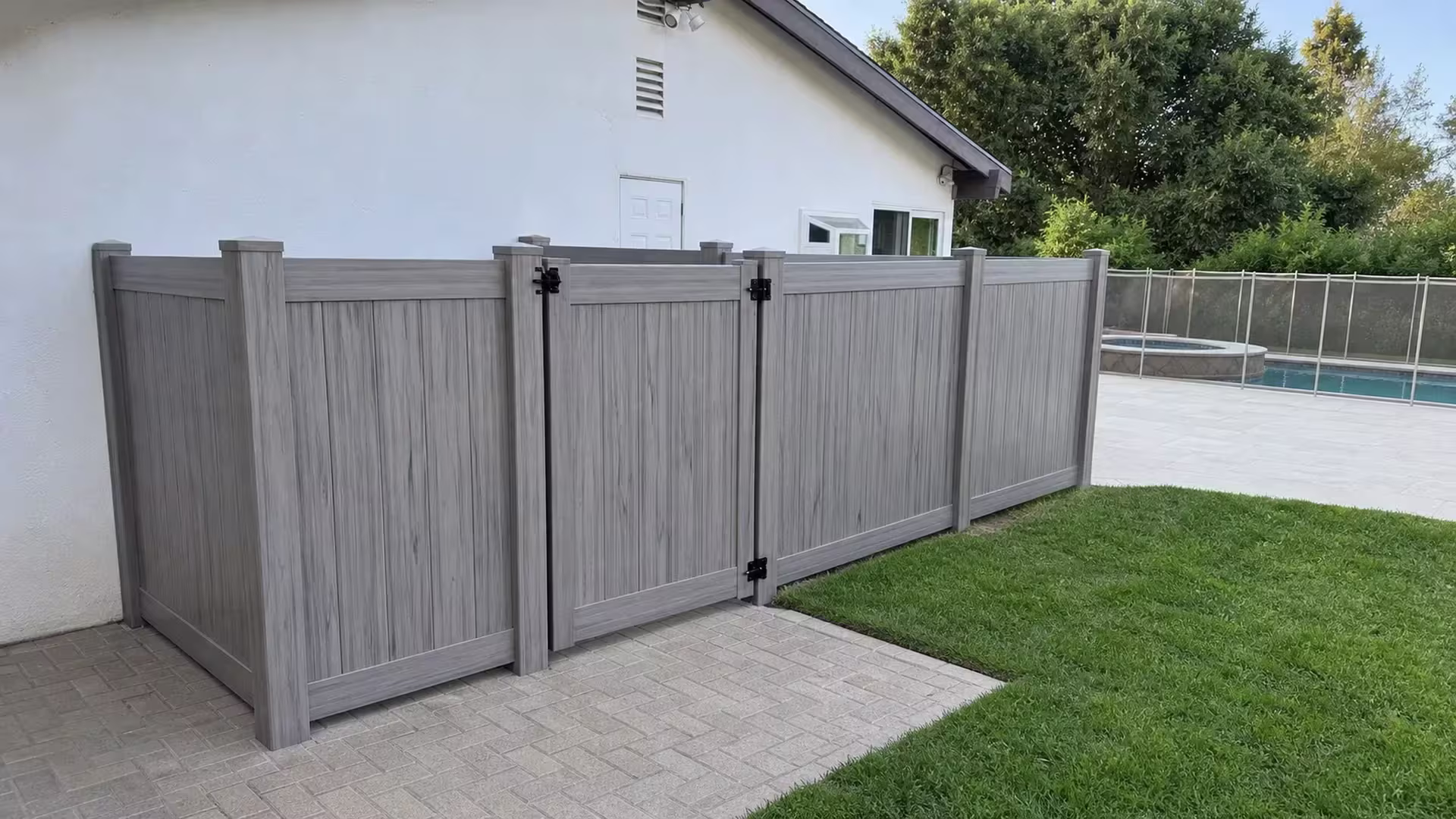 Coastal Cedar vinyl fence encloses Encino mechanical equipment with a raised pool and metal railing visible beyond