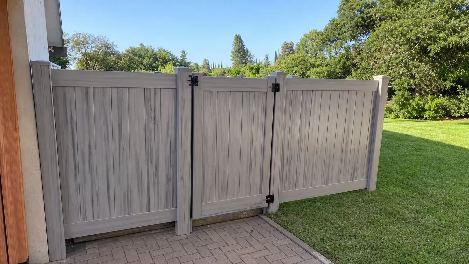 This Coastal Cedar vinyl privacy fence and gate sit between the house wall and an open lawn in Encino