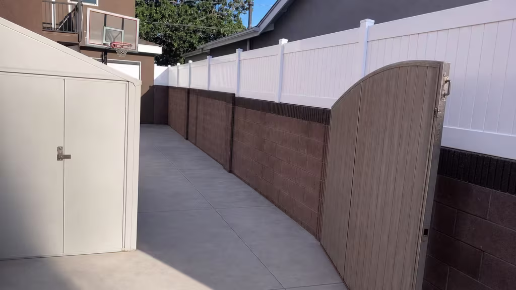A basketball hoop and a storage shed stand near this Lakewood stretch of White vinyl privacy wall topper