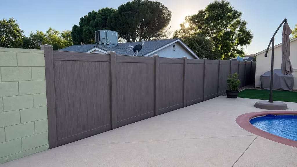 An HVAC unit and satellite dish top the neighboring roof above this Dark Walnut vinyl privacy fence line in Granada Hills